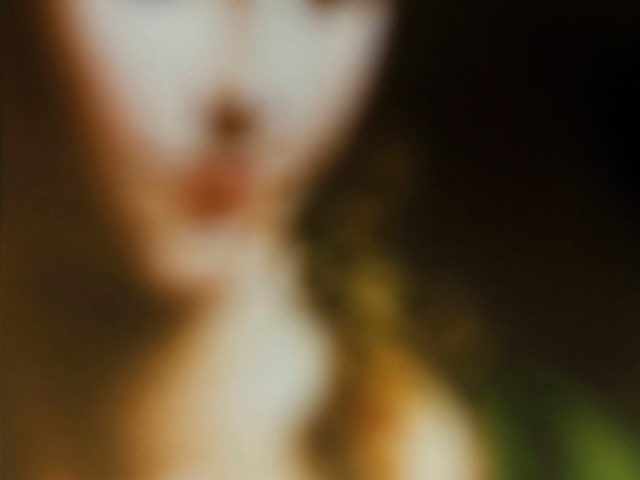 A blurred image of a renaissance painting of a beautiful woman with brown hair.