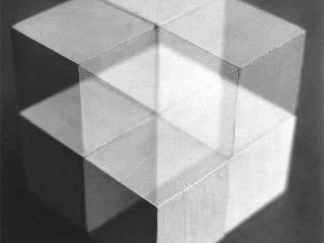 This is a black-and-white multiple-exposure photograph of white-painted wood cubes.