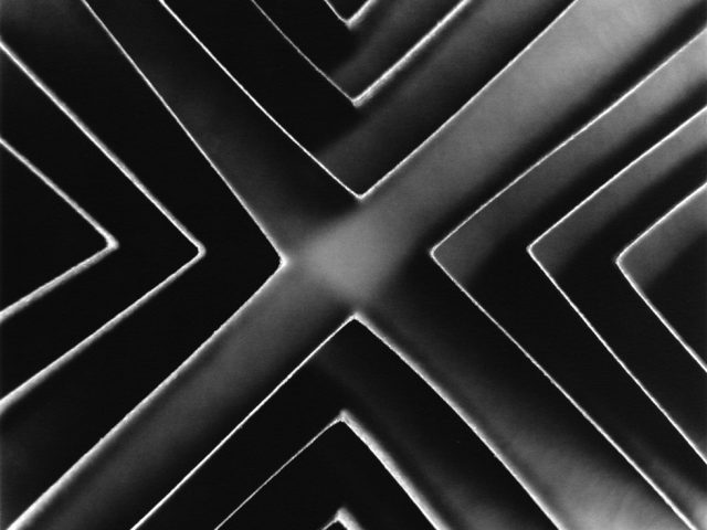 This is a black-and-white photograph of a paper sculpture of geometric shapes seen from above.