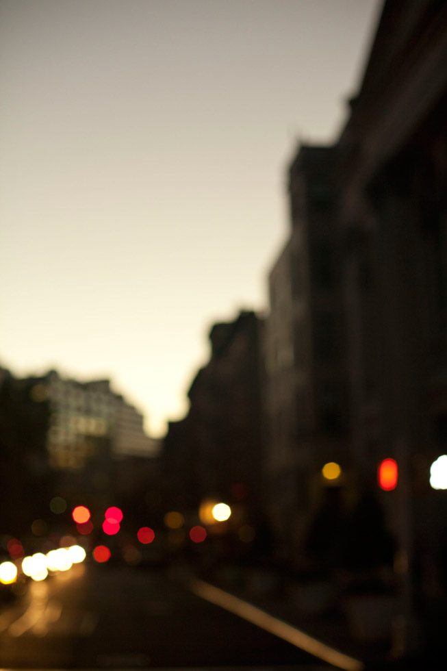 An out of focus photograph of a street just after the sun has set