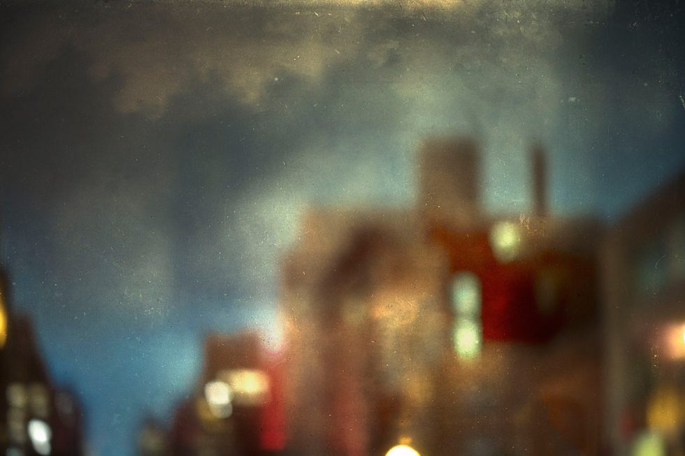 A soft focus photograph of a buildings with a dark blue evening sky behind them