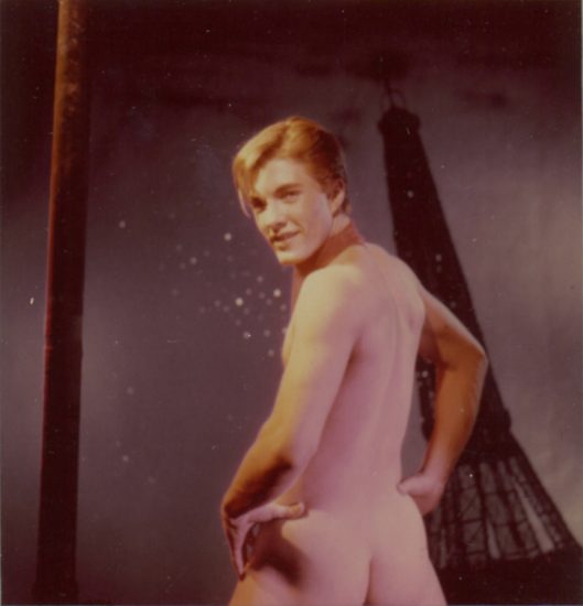 A James Bidgood photograph of a model named Apache standing naked in front of the Eiffel Tower