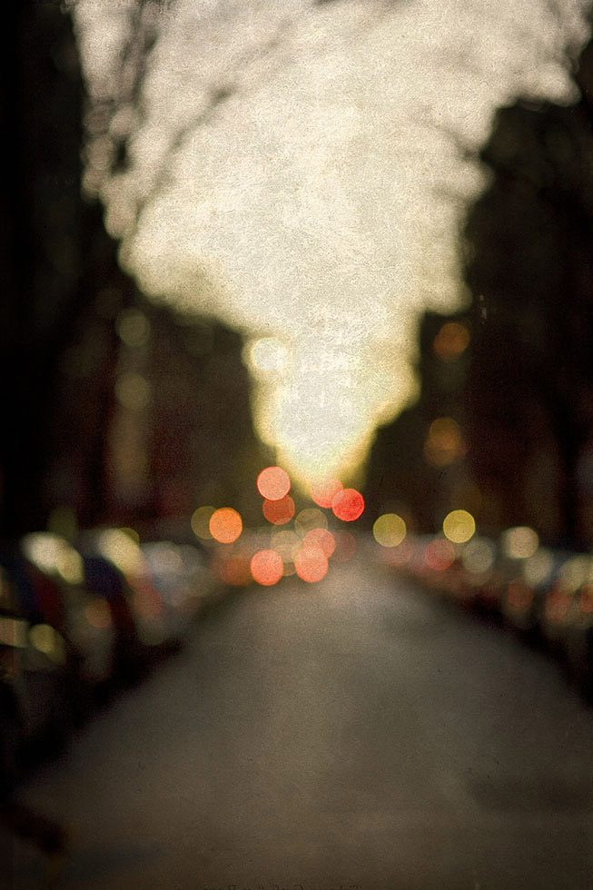 An out of focus photograph of a street in the West Village at dusk