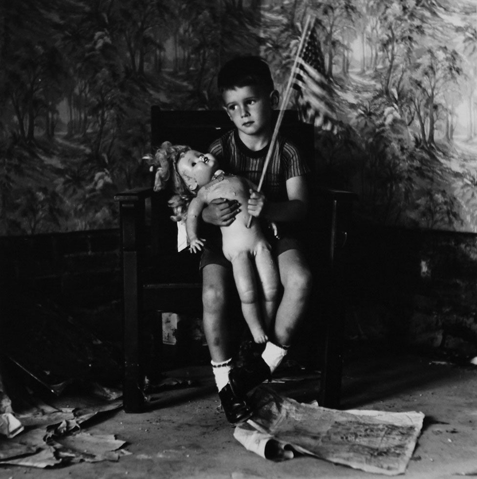 Untitled (Boy with Flag) [Christopher and the Rebuilding of America] by Ralph Eugene Meatyard