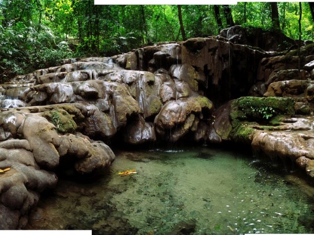 A photograph of a body of water in front of rocks.