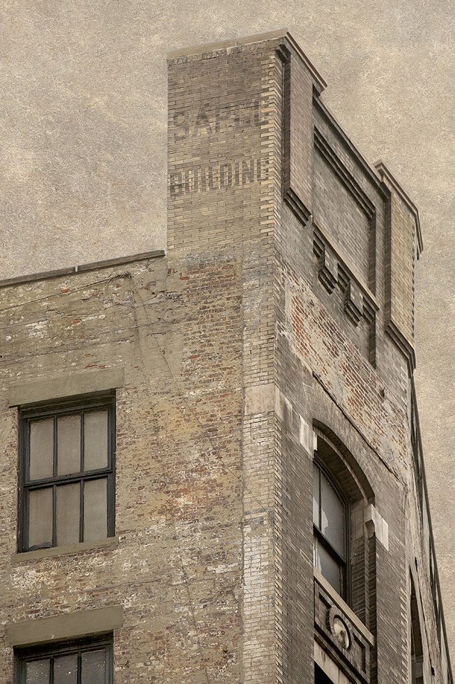 The side of a brick building in New York with the faded words “Sapco building” written on the side