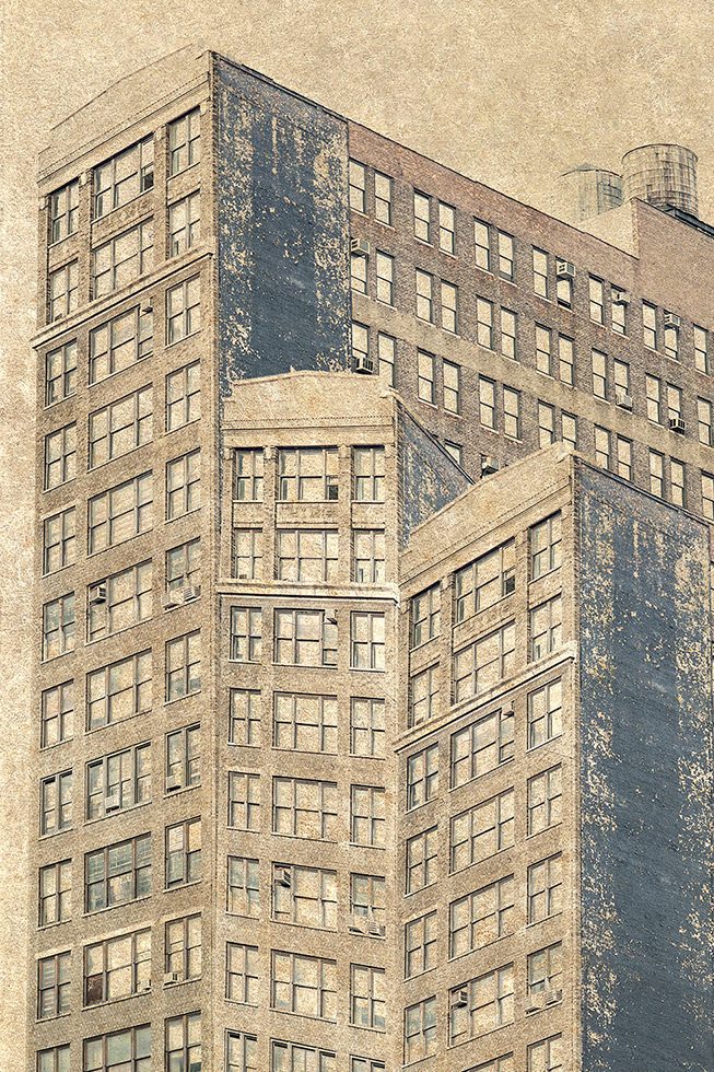 A photograph of three brick buildings next to each other, all different sizes, somewhere in New York City