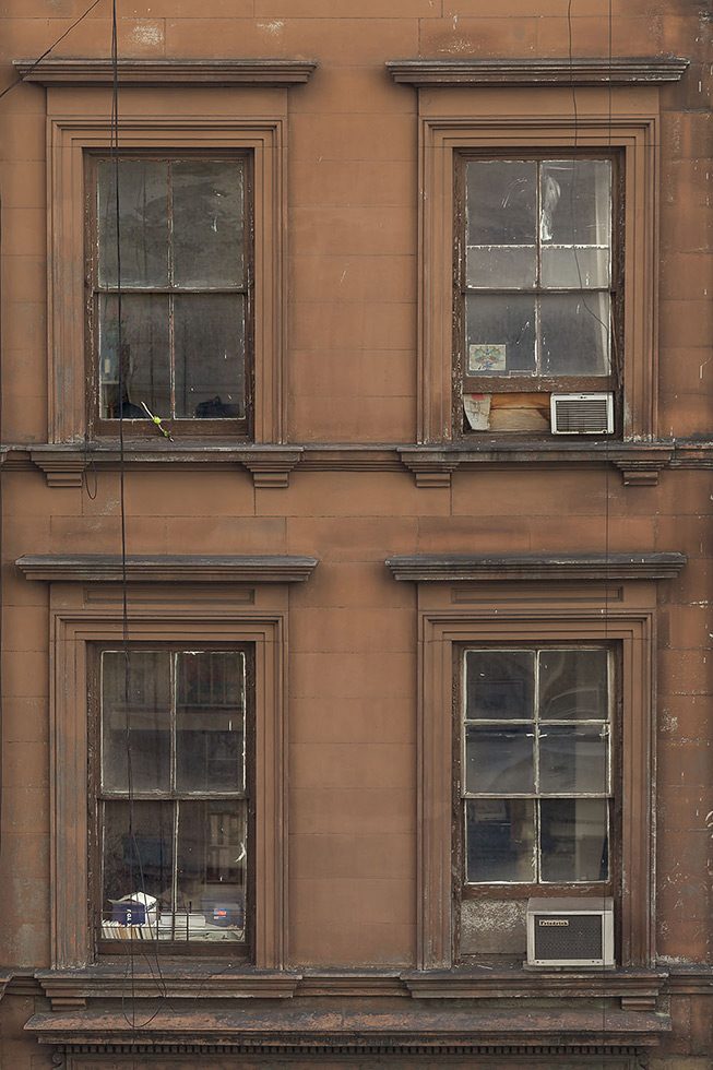 A photograph of 4 windows in a building in New York City