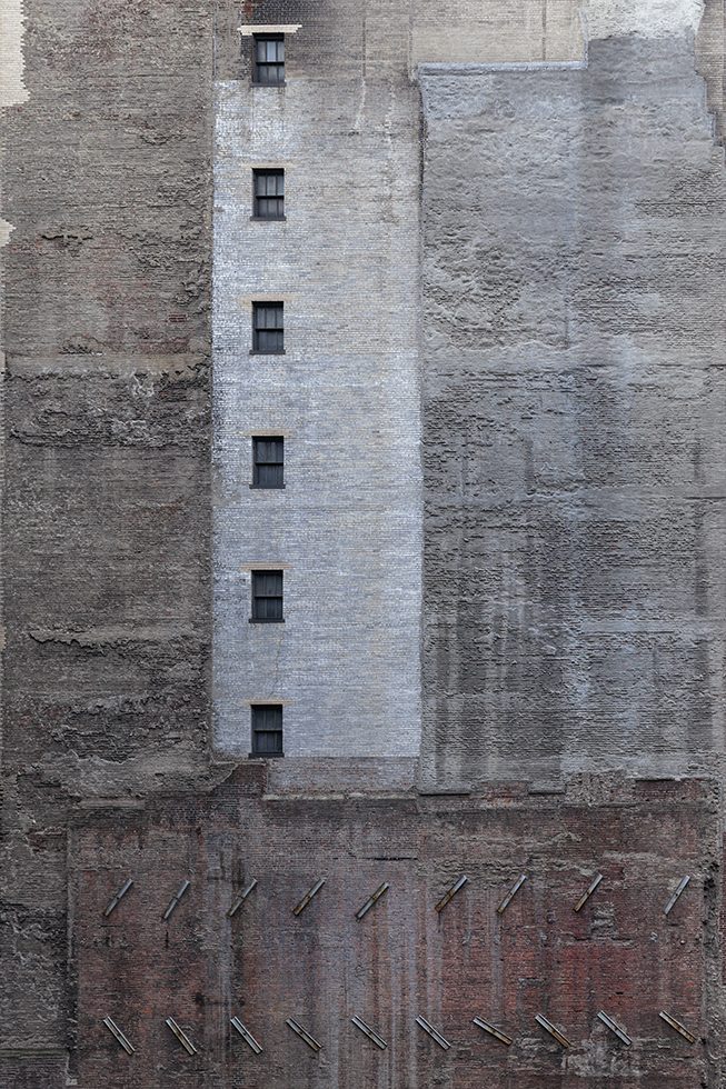 A photograph of the side of a building with a brick and concrete