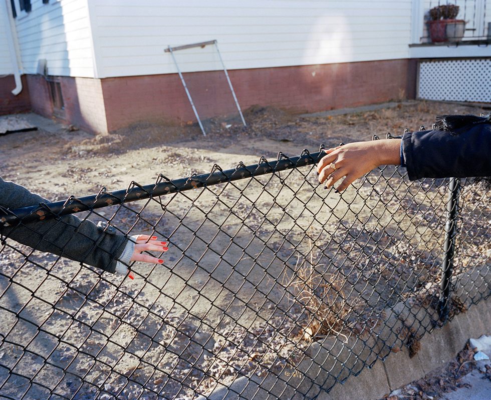 Reaching through a fence by Paolo Morales