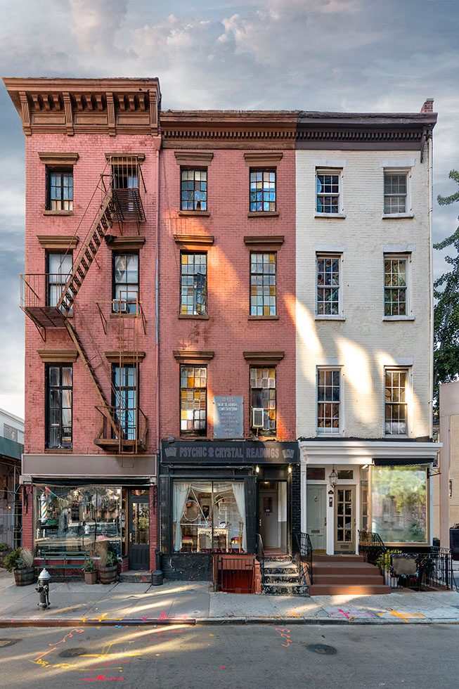 A photograph of three small apartment buildings in New York City