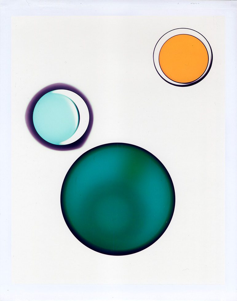 This is an image of a large blue-green circle, a medium yellow circle, and a small blue circle floating on a field of white.