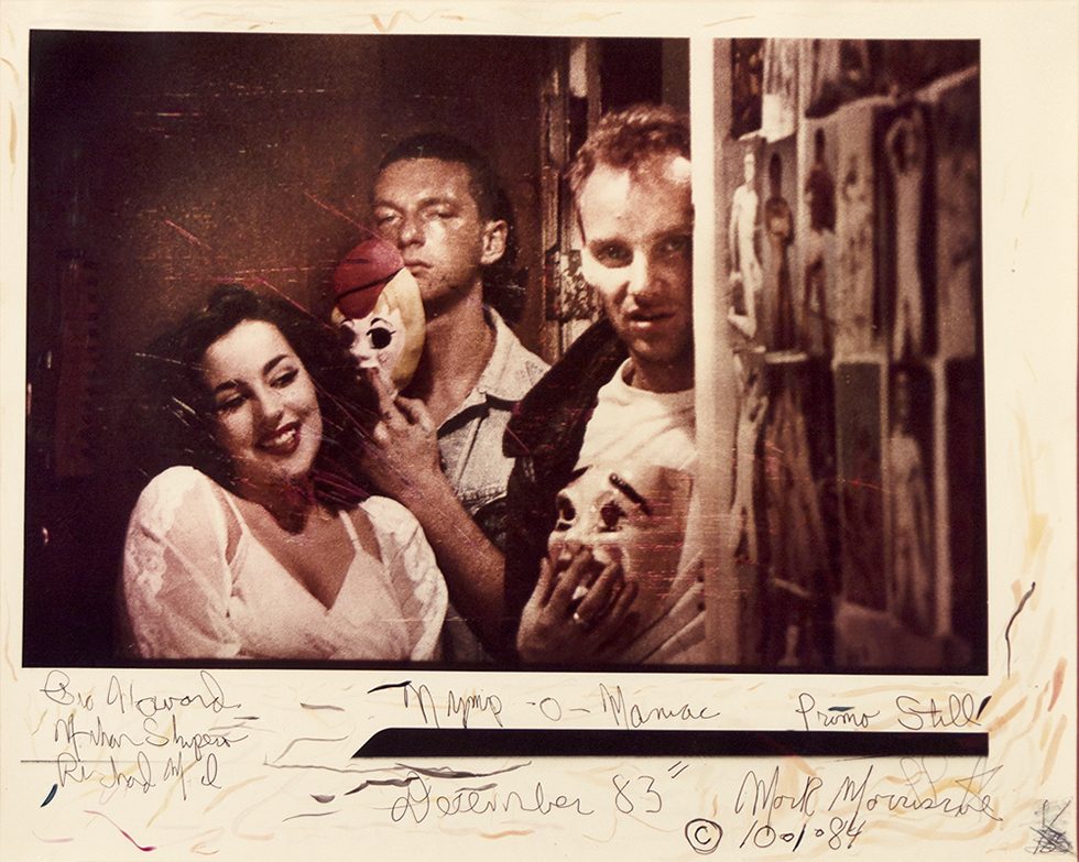 This is a color photograph of three young people—two holding masks.