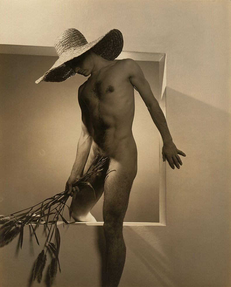 José Martinez holding long stem flowers and wearing a large straw hat