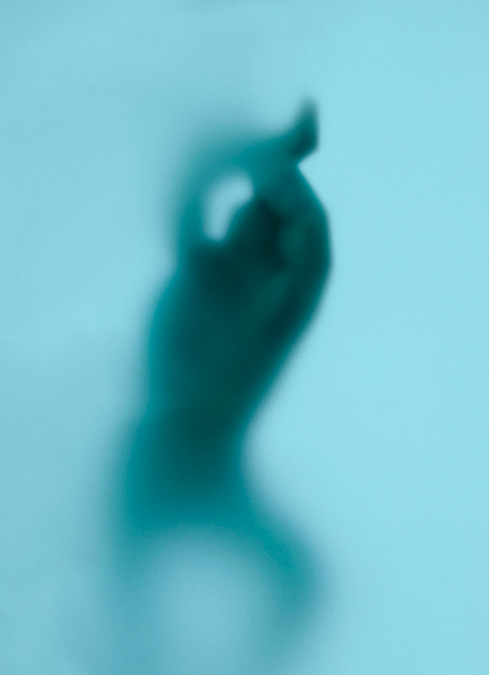 A baby blue rectangle with a vaguely human like form coming in and out of focus.