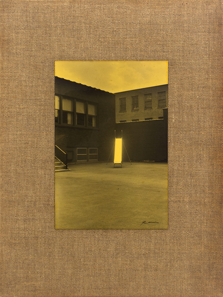 This is a varnished black-and-white photo of a slide in a schoolyard mounted to a linen bookcover by Joseph Mills.