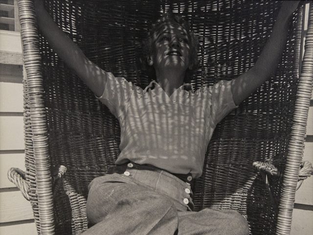 Katherine Anne Porter sitting in large wicker chair