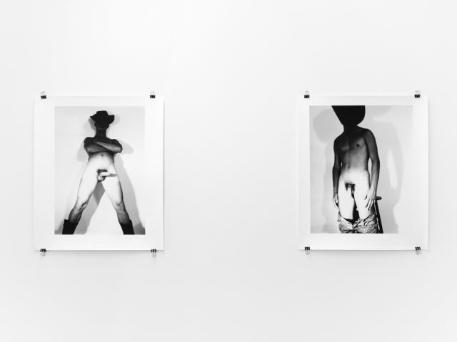 An installation photograph of black and white photography in a white-walled gallery space.
