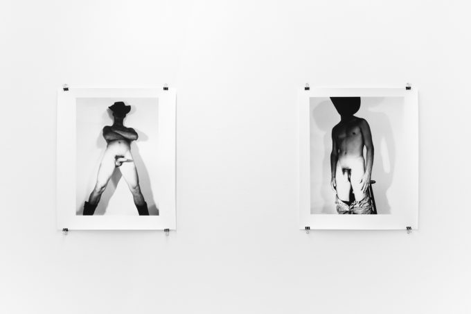 An installation photograph of black and white photography in a white-walled gallery space.