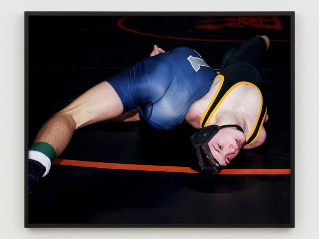 This is a photograph of two young men wrestlers on the mat.