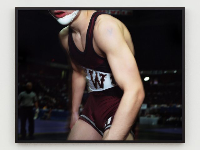 This is a photograph of the body of a young wrestler slightly hunched.