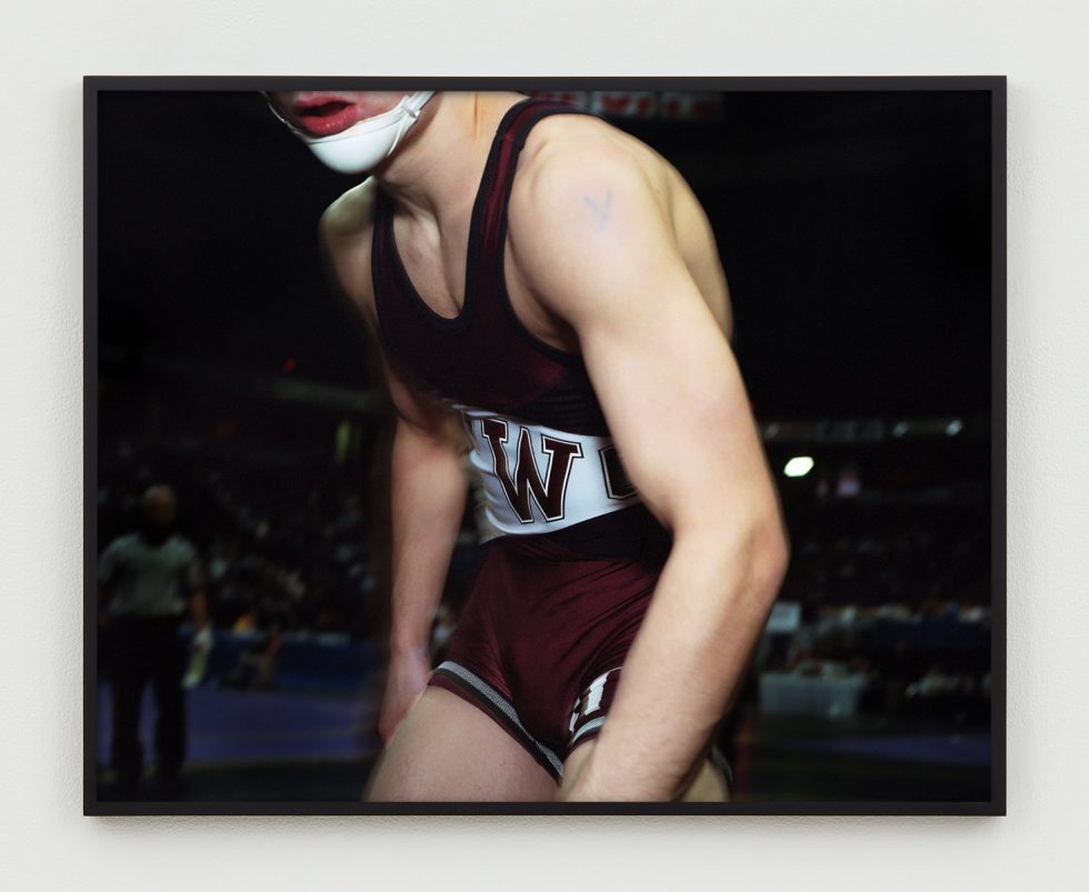 This is a photograph of the body of a young wrestler slightly hunched.