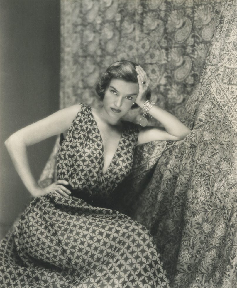 Woman sitting facing the camera with a star patterned dress