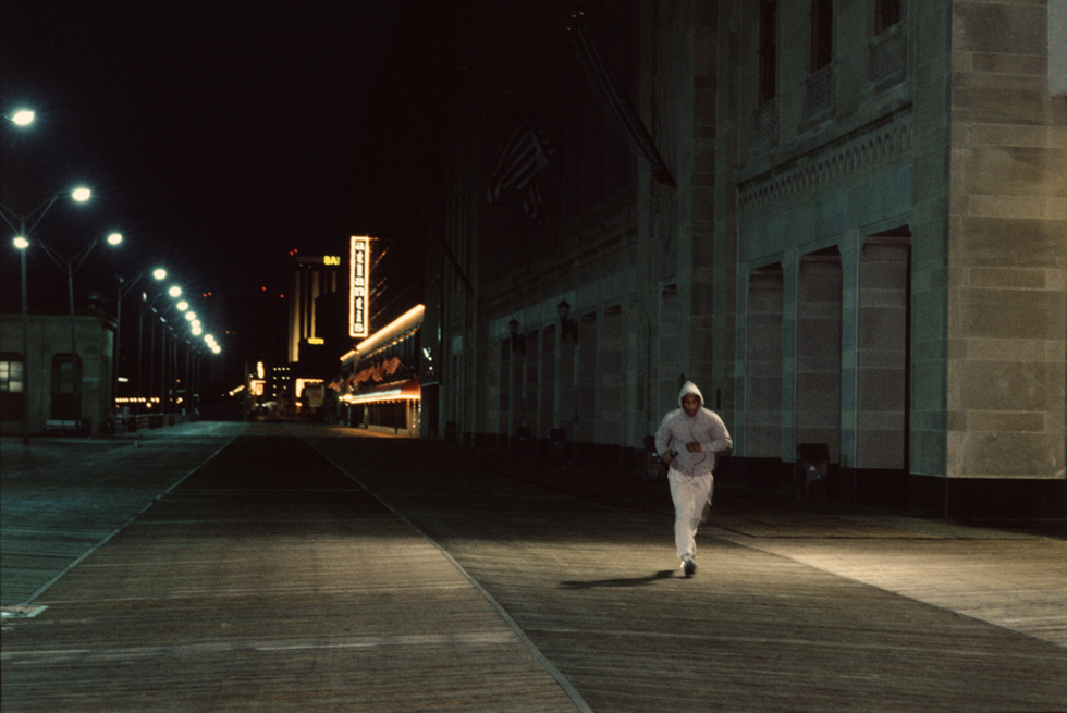 A photograph of Mike Tyson running on the boardwalk at dawn in Atlantic City , NJ in June 1988.