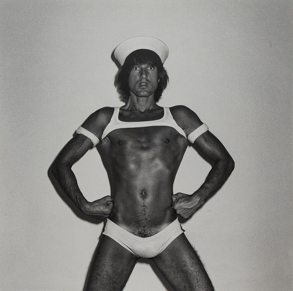 Black-and-white photograph of a man wearing a sailor cap and white armbands.