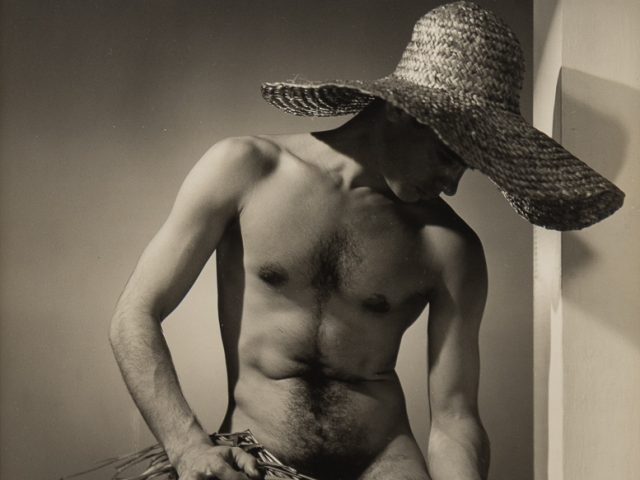 Black and white photograph of José Martinez nude wearing a large straw hat