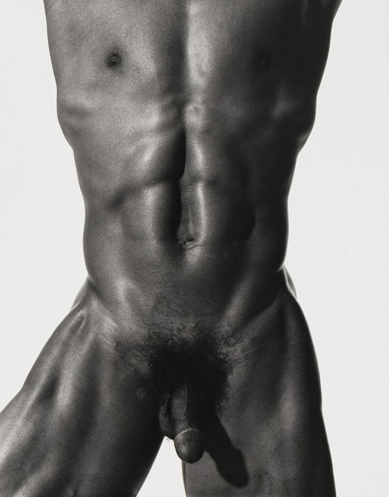 This is a black-and-white photograph of a fit Black man's naked torso from his mid-thighs up to his neck.