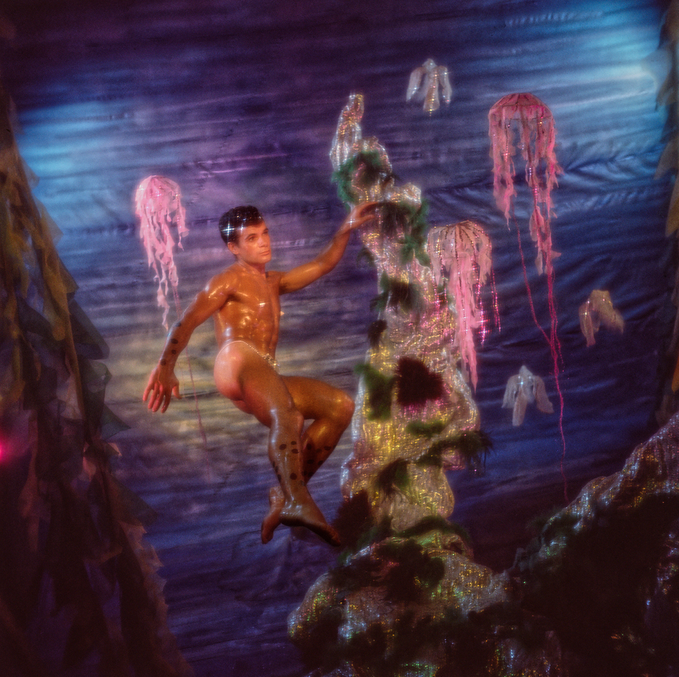 A colorful James Bidgood photo of a man underwater with a jellyfish