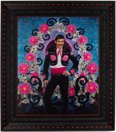 This is a colorful painted photograph of a male Mexican singer displayed in an elaborate black frame with pink hearts.