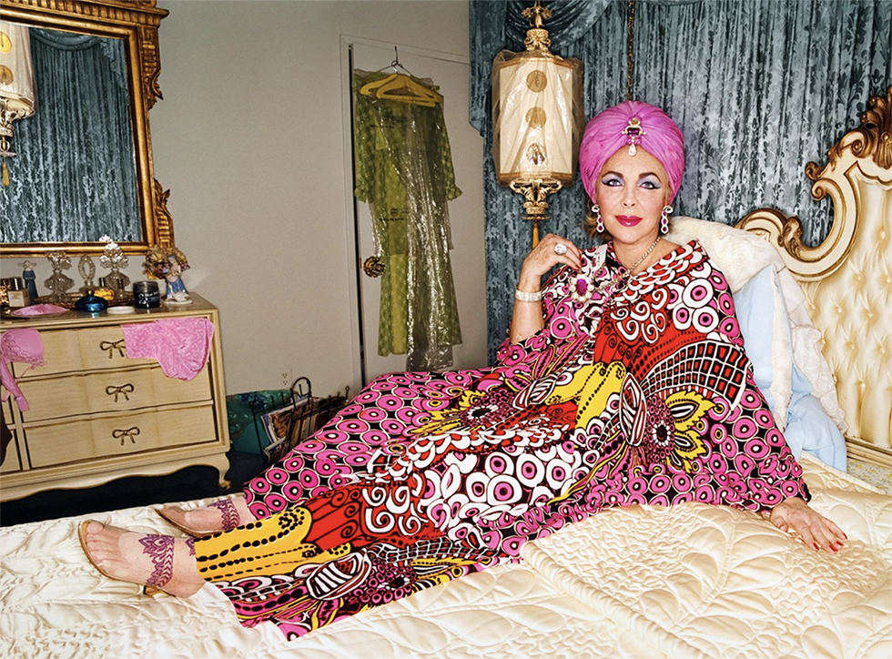 A color photograph by fashion photographer David LaChapelle of Elizabeth Taylor in a pink kaftan with pink turban in a bed