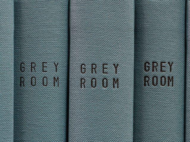 This is a photograph of grey book spines which all say "GREY ROOM," taken by artist Mickey Smith.