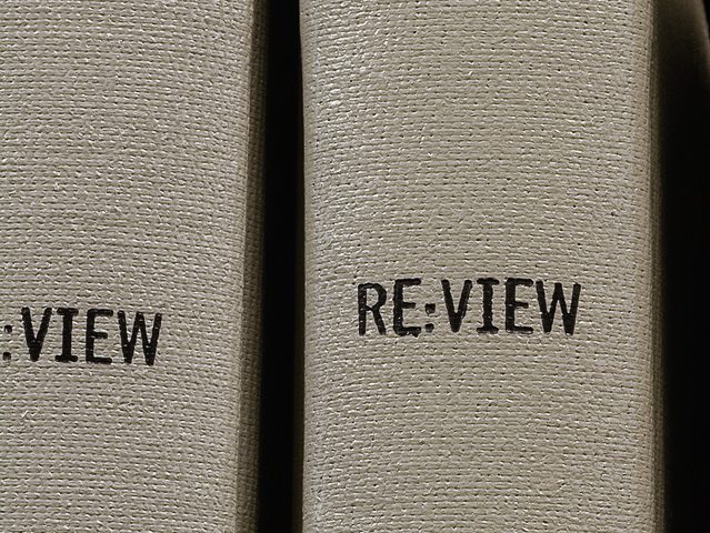 This is a photography by artist Mickey Smith of two grey book spines that each read "RE:VIEW."