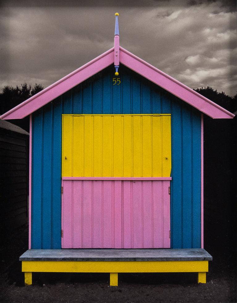 This is a photograph by Judy Gelles of an Australian Beach Box that is yellow, pink, and blue.