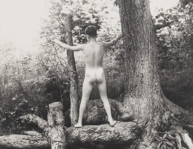 This is a black and white photo by PaJaMa of Bruce Peters Wescott nude from behind next to a body of water.
