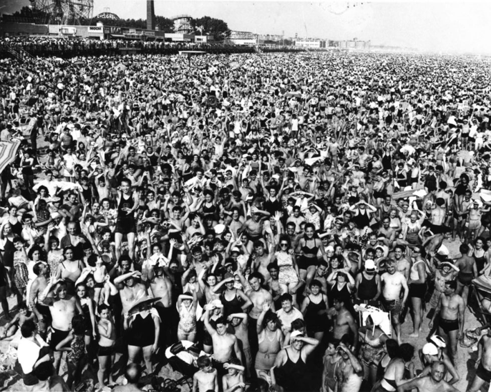 This is a black and white photograph by Weegee of an afternoon crowd at Coney Island