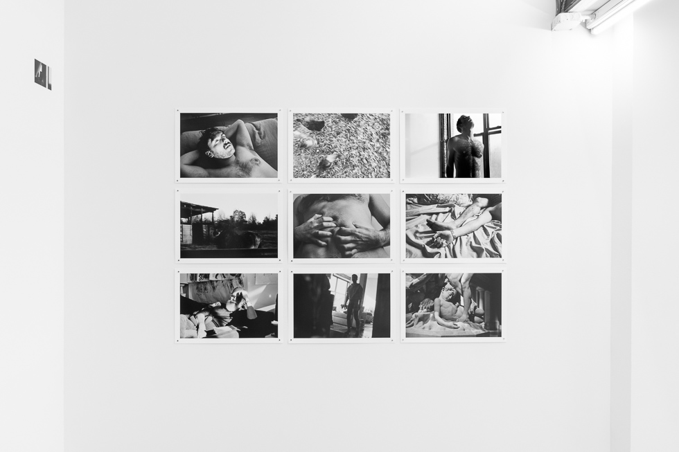 This is a photograph of a white-walled art gallery with black and white photographs on the wall.