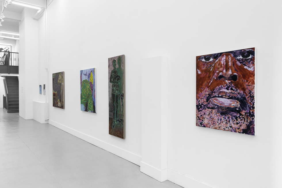 This is a photograph of a white-walled art gallery with colorful contemporary figurative paintings.