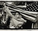 This is a photograph of a man holding up an american flag.