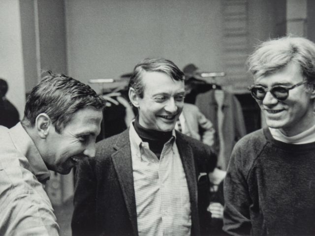 This is a black and white photograph of a group of three men at an event.