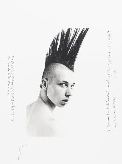 Click for sizes / editions / prices. This is a black-and-white photograph of a boy with a black mohawk looking back over his right shoulder.