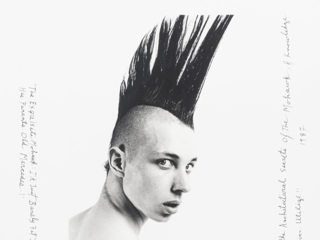 Click for sizes / editions / prices. This is a black-and-white photograph of a boy with a black mohawk looking back over his right shoulder.