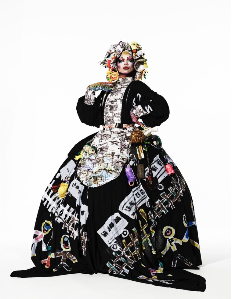 This is a photograph of a person wearing an elaborate costume in front of a white paper backdrop.