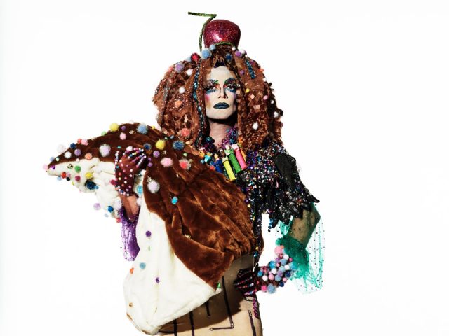 Click for sizes / editions / prices. This is a photograph of a person in an elaborate costume in front of a white background.