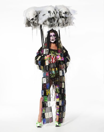 This is a photograph of a person in a colorful costume against a white backdrop.