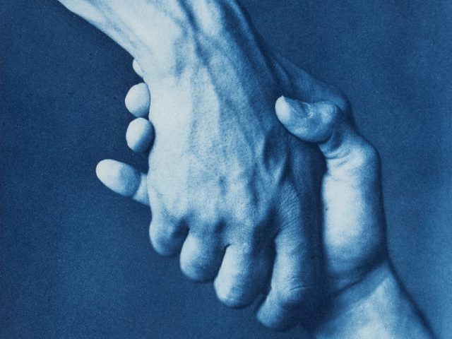 This is a cyanotype of two hands shaking against a plain backdrop.