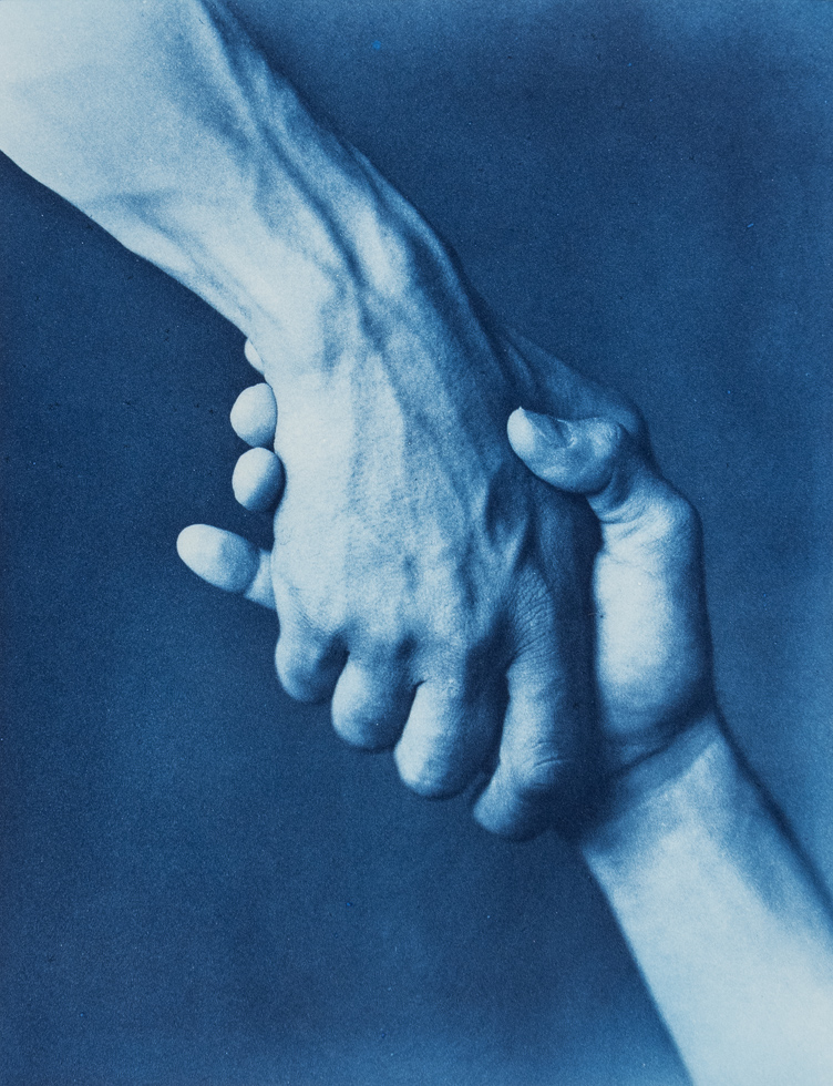 This is a cyanotype of two hands shaking against a plain backdrop.